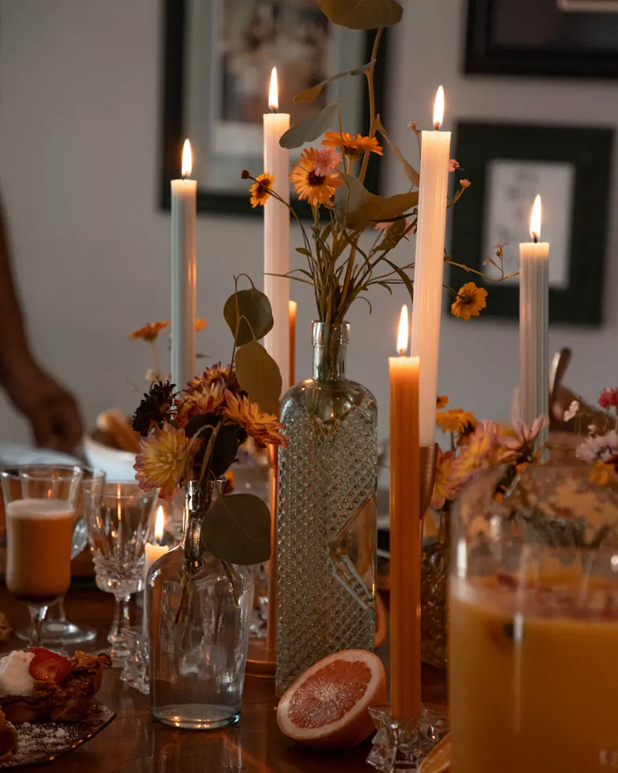 A dinner table set with candles, flowers and glassware