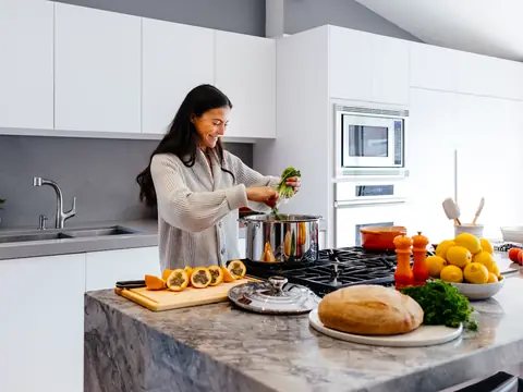 A woman preparing food in a bright, modern kitchen